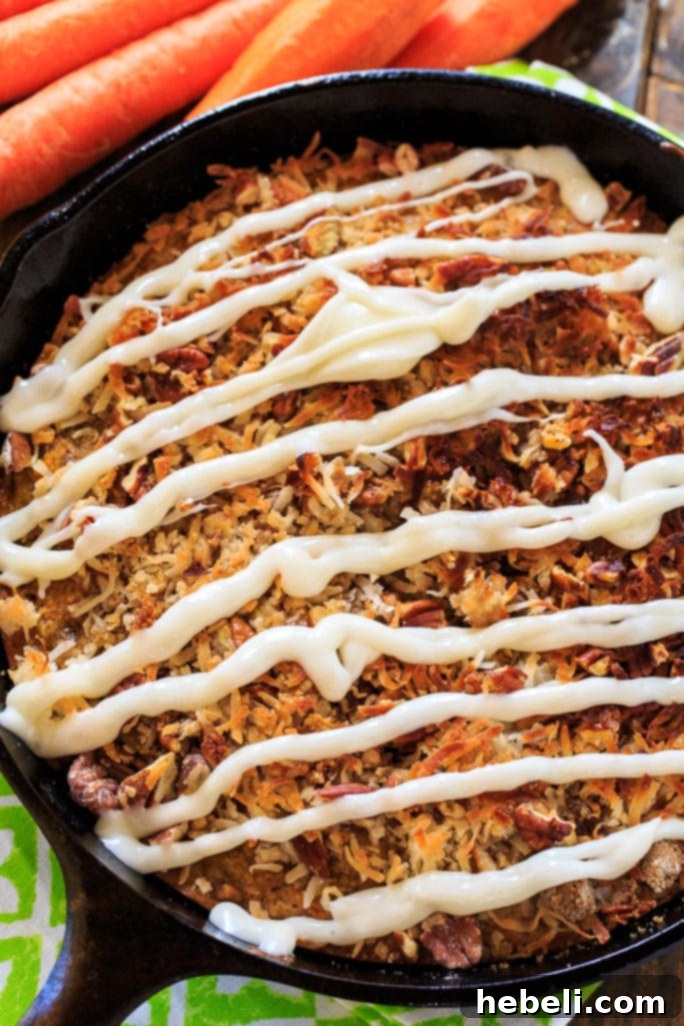 A close-up of a slice of Carrot Coffee Cake showing the moist interior, crumb topping, and cream cheese glaze