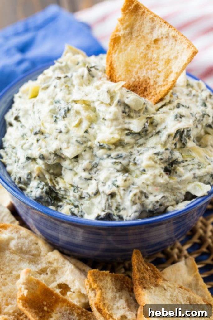 Creamy Crock Pot Spinach Artichoke Dip 4 Close-up of Crock Pot Spinach Artichoke Dip bubbling and melting in a slow cooker