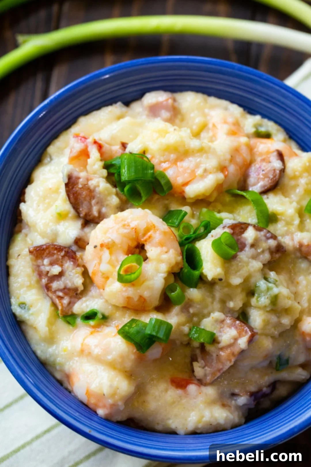 Jambalaya Grits served in a blue bowl, garnished with green onions.