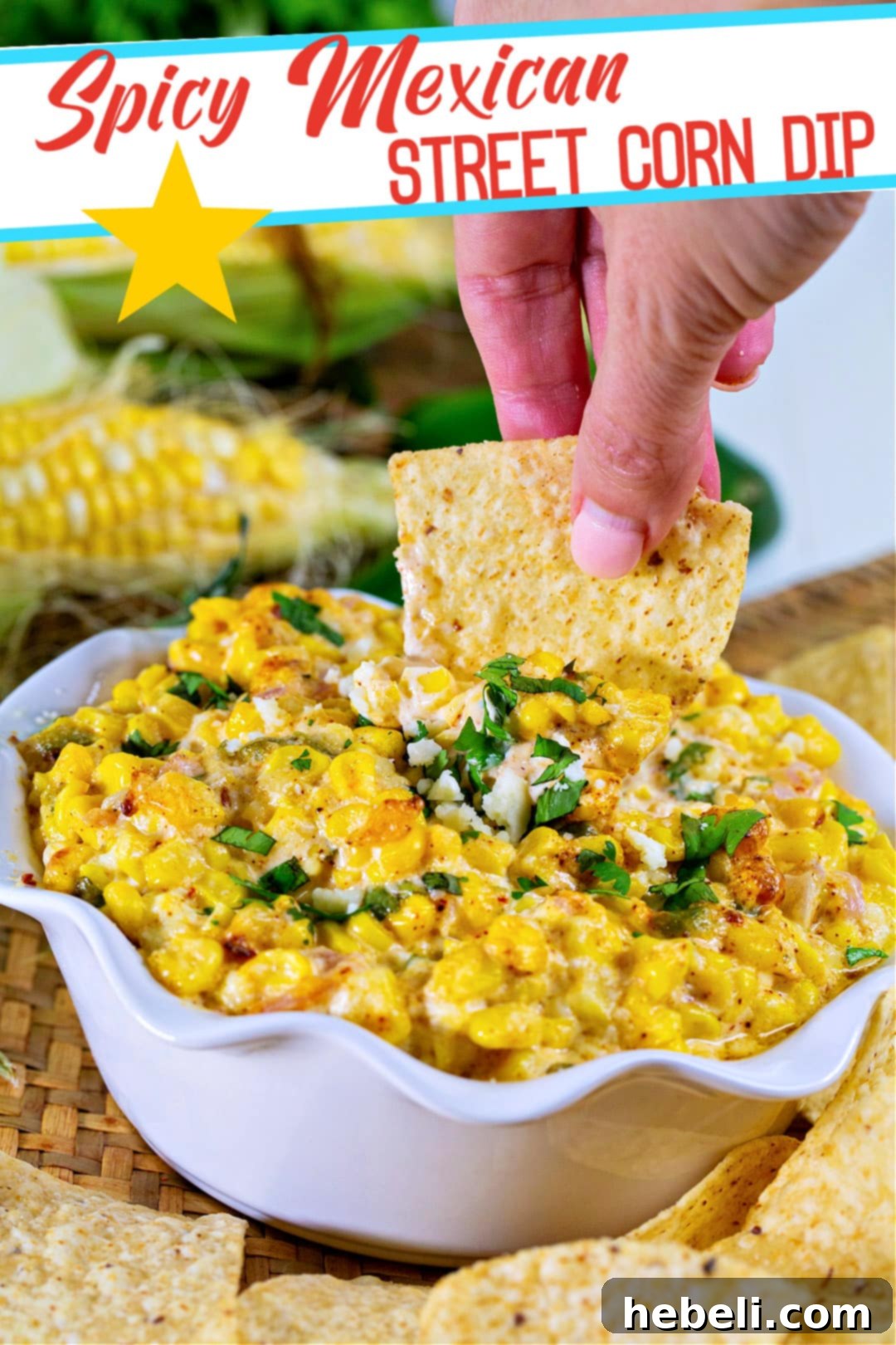 A close-up shot of a hand dipping a crispy tortilla chip into a warm and bubbly Spicy Mexican Street Corn Dip, highlighting the irresistible texture and vibrant colors.
