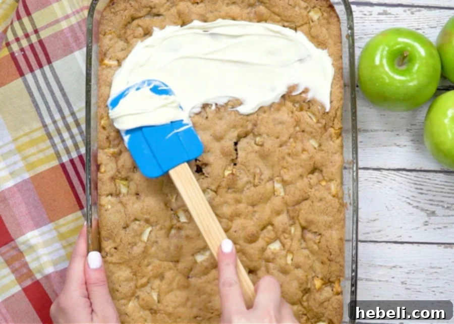 Homestyle German Apple Cake 8 Thick, creamy frosting being spread smoothly over the cooled German Apple Cake.