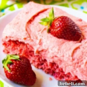 Perfect Strawberry Sheet Cake 6 Slice of Strawberry Sheet Cake on a plate with a fresh strawberry.