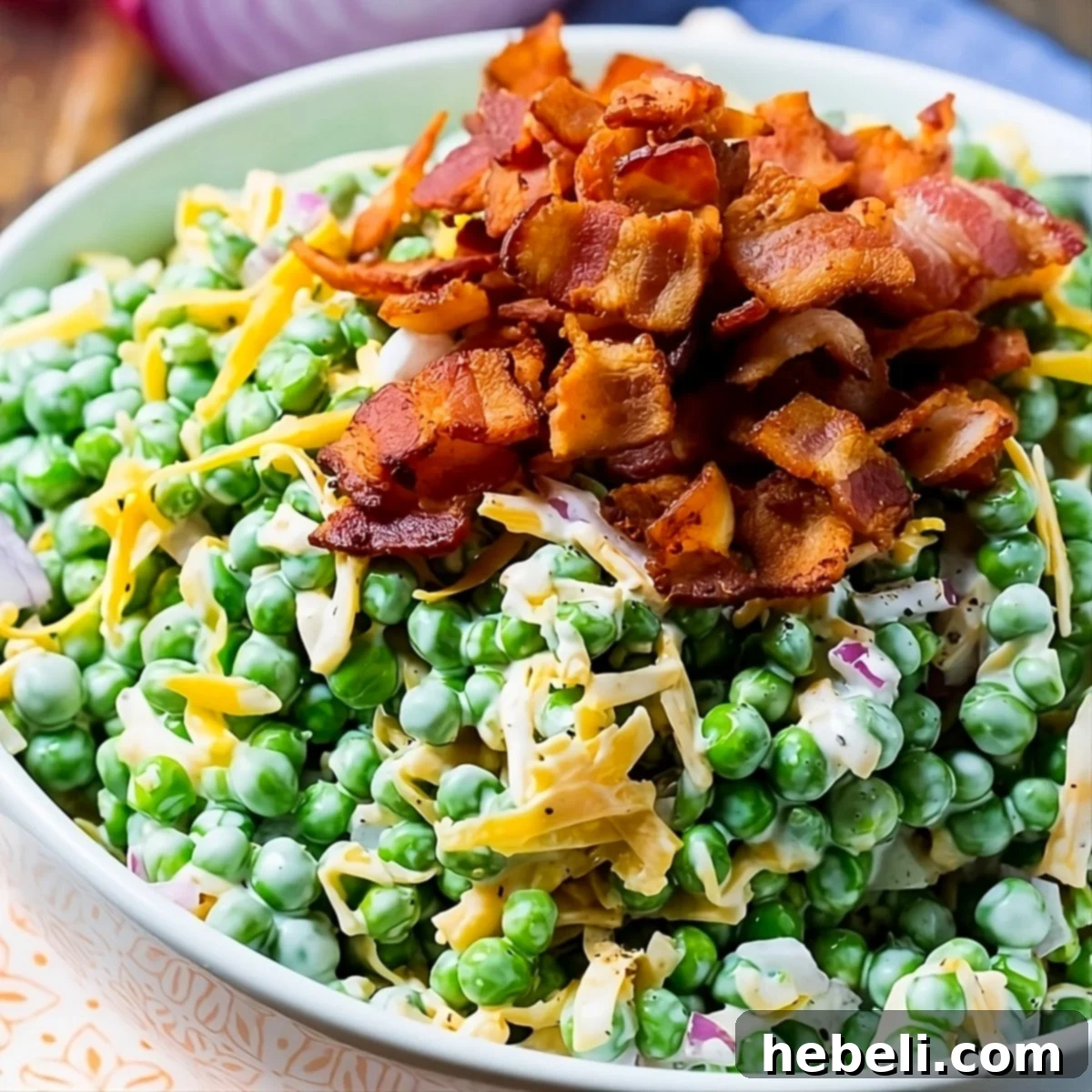 Creamy Pea Salad topped with crispy bacon in a rustic serving bowl, ready for a potluck.