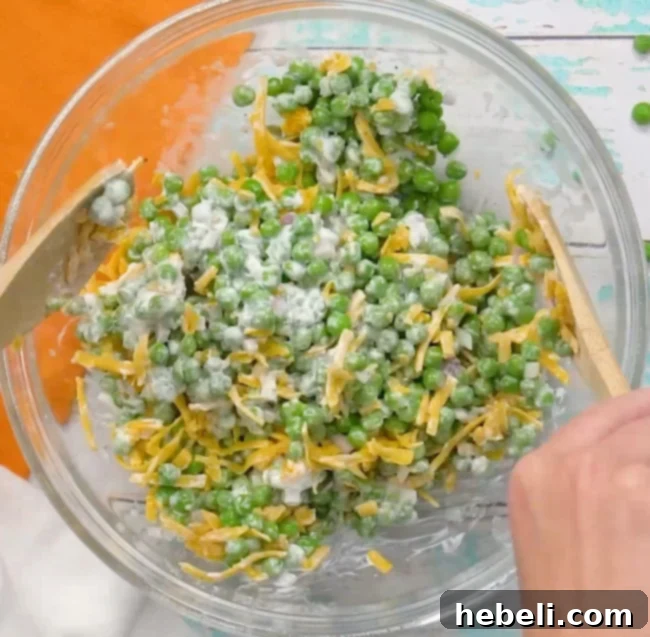 Mixing the pea salad ingredients in a bowl.