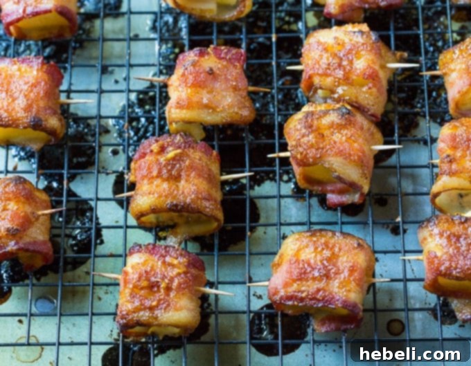 Spicy Bacon Wrapped Pineapple Bites neatly arranged on a white serving dish.