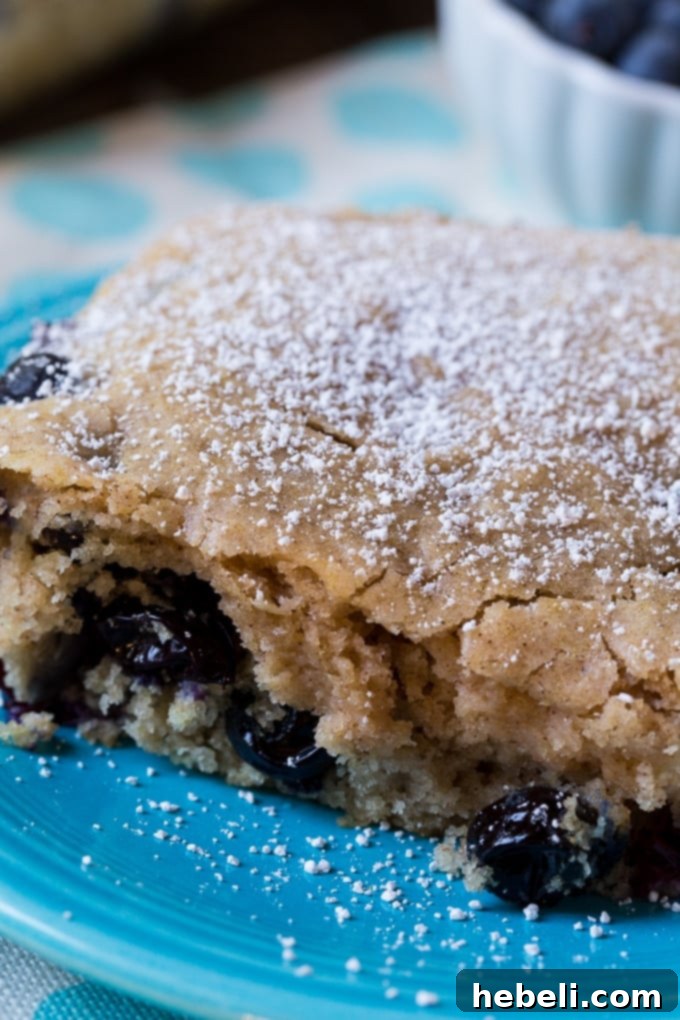 Fluffy Blueberry Pancake Dream 3 Close-up of a warm Blueberry Pancake Cake with powdered sugar
