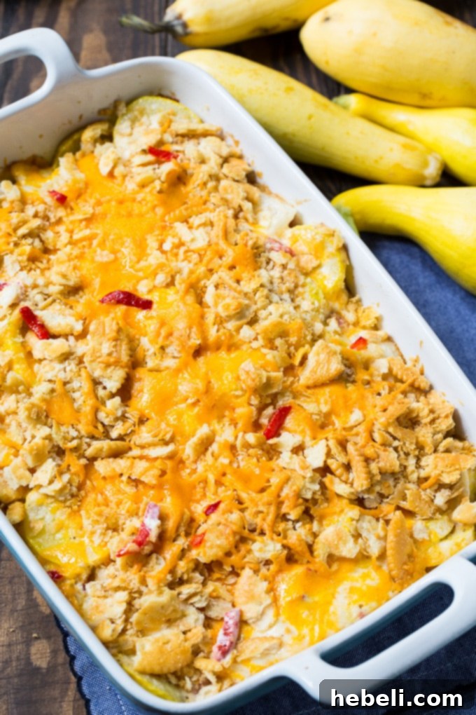 Close-up of Pimento Cheese Squash Casserole, highlighting the cheesy, creamy interior and specks of red pimentos.