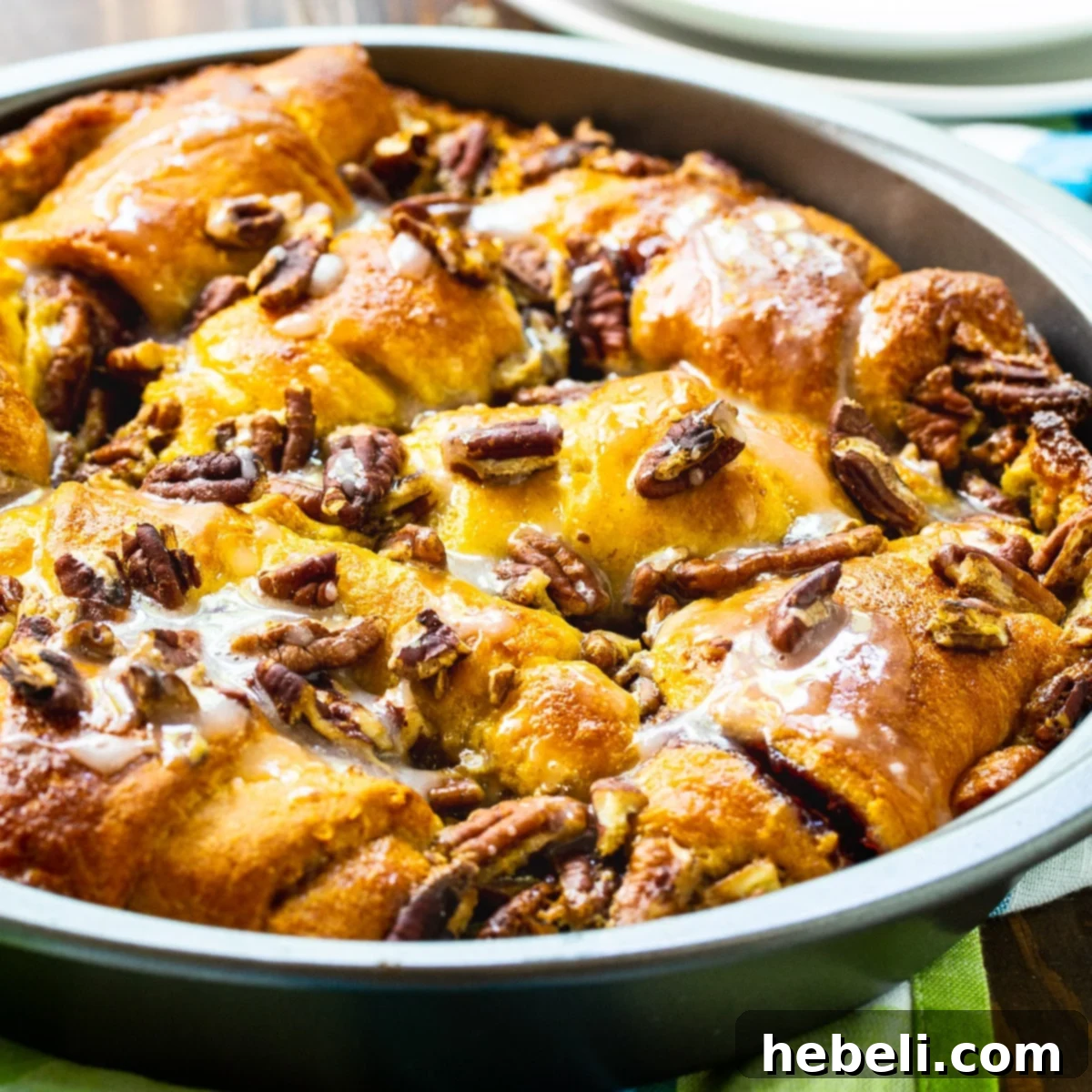 Golden Crescent Coffee Swirl 2 Buttery Crescent Roll Coffee Cake in a 9-inch cake pan, garnished with raspberry preserves and pecans.