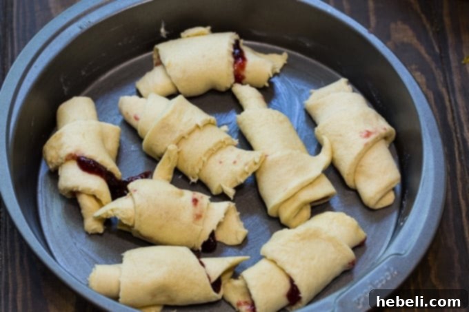 Golden Crescent Coffee Swirl 5 Close-up of a slice of Crescent Roll Coffee Cake with a fork, highlighting the raspberry preserves.