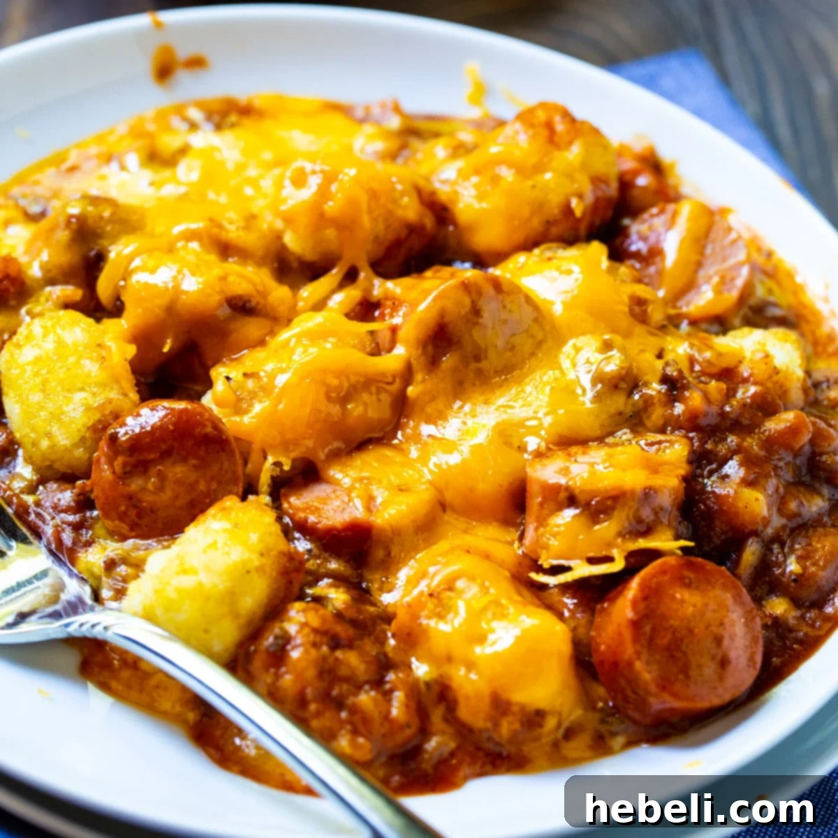 A serving of Cheesy Hot Dog Tater Tot Casserole on a plate, showcasing melted cheese and crispy tater tots.