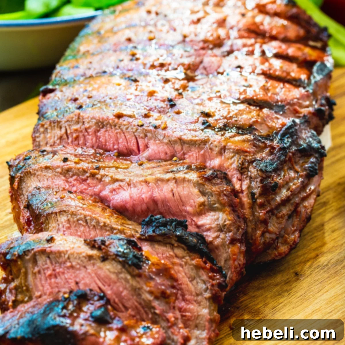 Perfectly grilled Catalina London Broil slices arranged on a wooden cutting board, ready to serve.