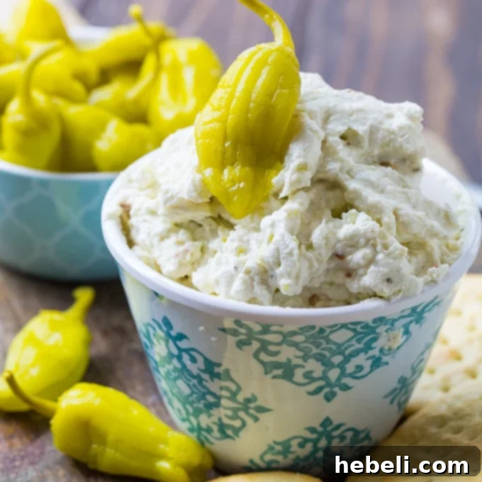 Three Cheese Pepperoncini Spread, a creamy and spicy Mediterranean-style appetizer perfect for parties, served with crackers.