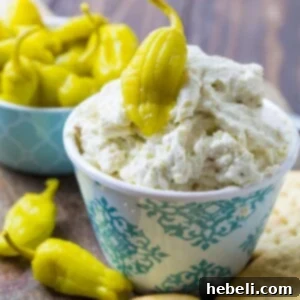 Three Cheese Pepperoncini Spread in a serving bowl with fresh parsley garnish, ready to be enjoyed with crackers.