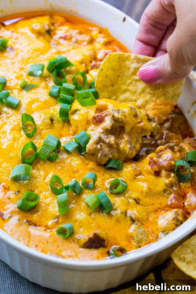 Scoops of Spicy Sausage Cheese Dip being served, highlighting its rich color and inviting texture.