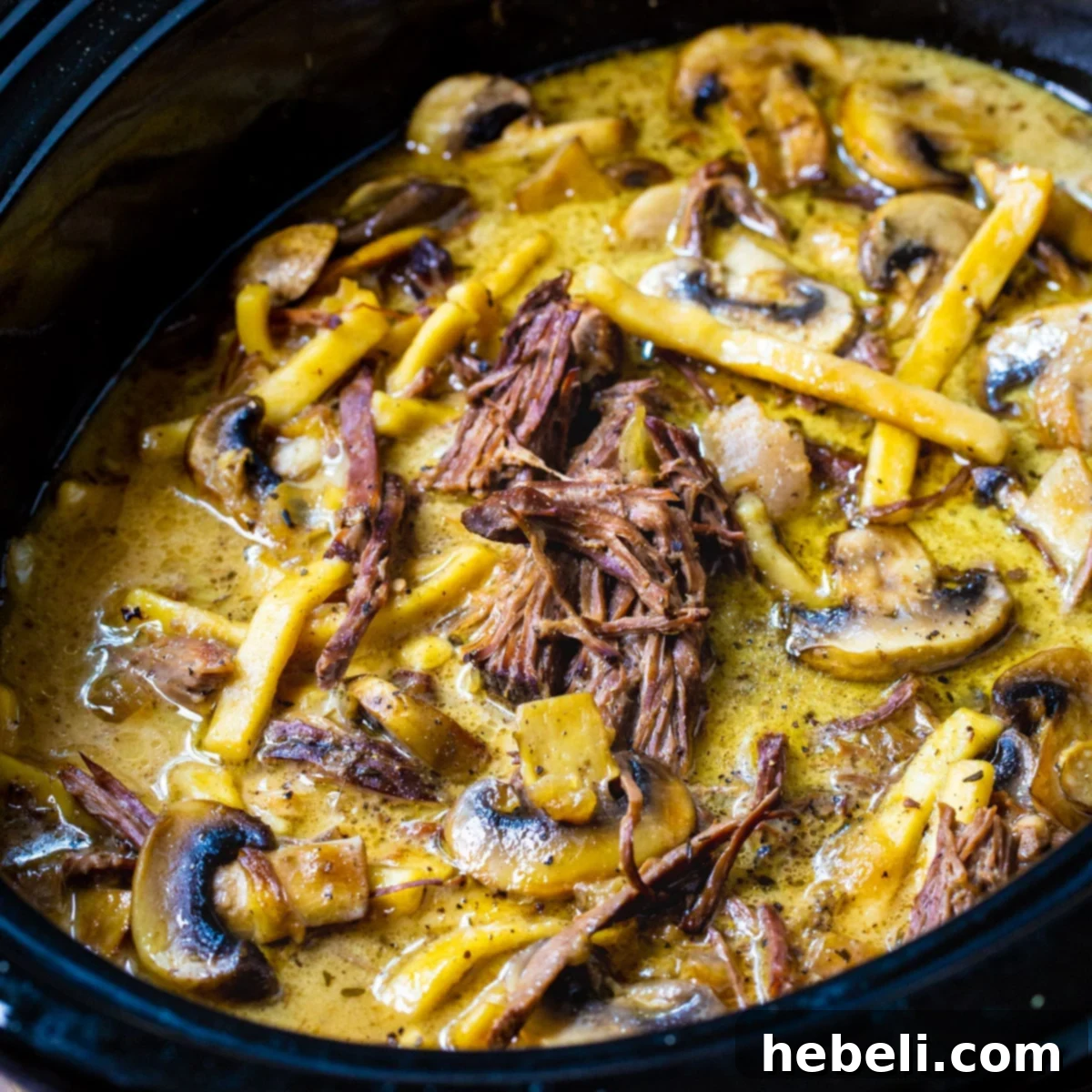 A delicious bowl of Slow Cooker Beef and Noodles with Mushrooms, garnished and ready to serve.