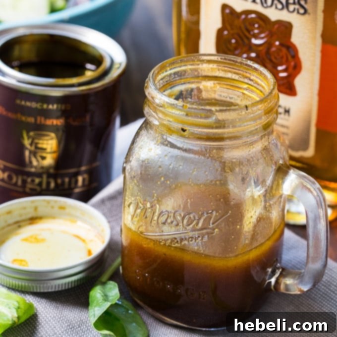 Golden Bourbon Sorghum Dressing 2 Freshly made Bourbon Sorghum Vinaigrette in a glass jar, ready to be served over mixed greens for a Southern-inspired meal.