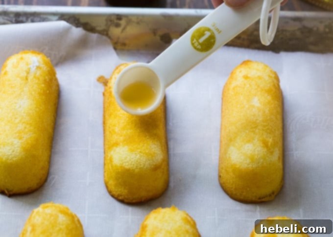 Twinkies being carefully soaked with bourbon, preparing for chocolate dip