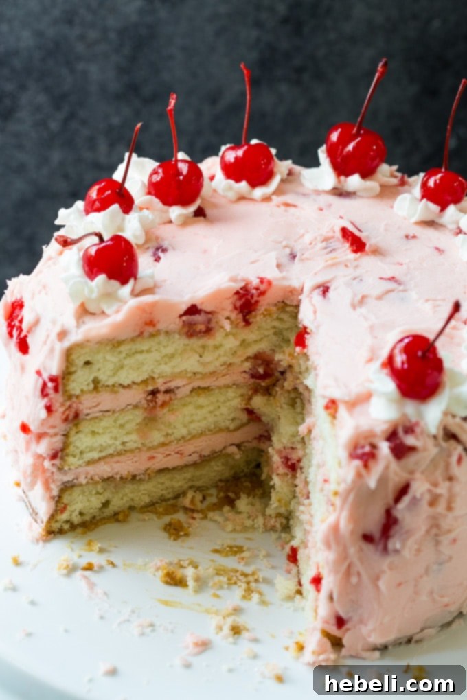 Close-up of a slice of White Cake with Maraschino Cherry Frosting showing layers