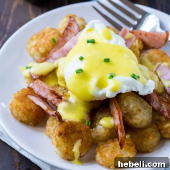 Golden Tater Tot Benedict 2 Tater Tot Eggs Benedict served on a plate with Canadian bacon and fresh herbs, highlighting the crispy tater tots base.