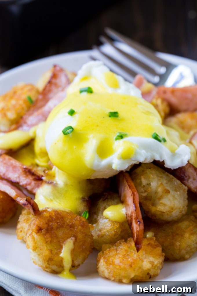 Golden Tater Tot Benedict 4 Plated Tater Tot Eggs Benedict, three servings with vibrant Hollandaise and fresh herbs, ready to be enjoyed.