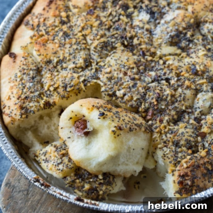 Golden brown Poppy Seed Sausage Rolls arranged on a serving platter, ready for a party.
