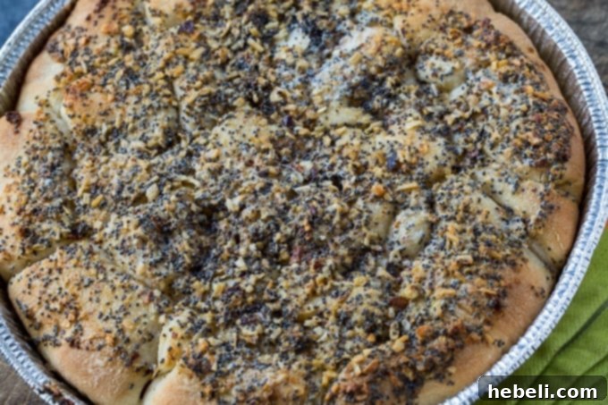 Poppy Seed Sausage Rolls made with Sister Schubert's Rolls arranged on a baking sheet before baking.