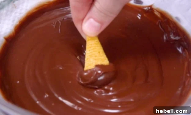 Dipping Bugles into melted chocolate.