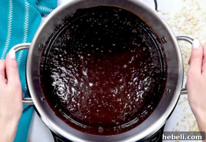 Chocolate mixture at a rolling boil in a saucepan, a critical step for perfect no-bake cookies.