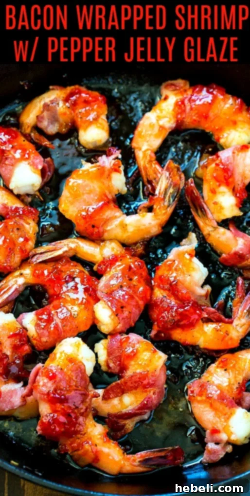 Close-up of shrimp wrapped in bacon in a cast iron pan, showing crispy texture.