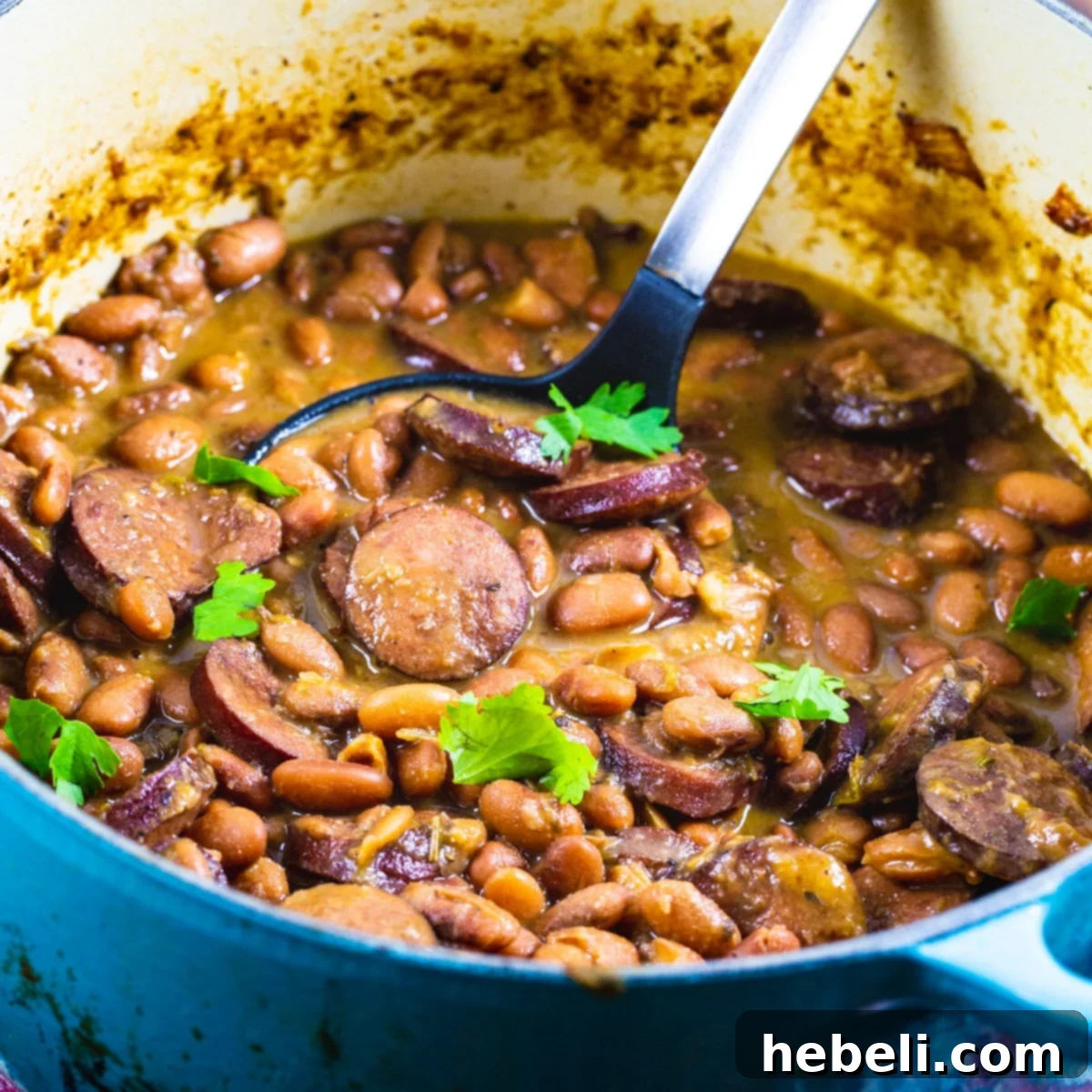 Hearty Pintos and Sausage simmering in a rustic Dutch oven.