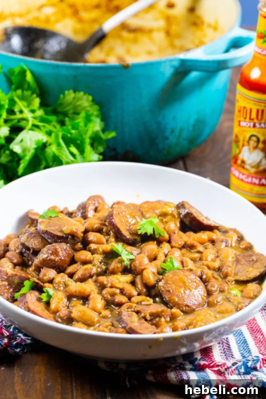 A serving of Pintos and Sausage in a rustic bowl, garnished.