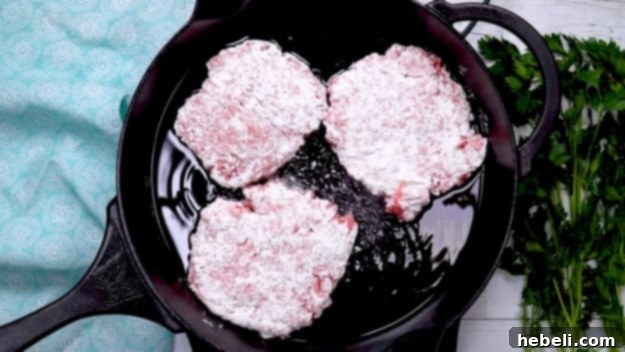 Smothered Steak Bites with Golden Onion Gravy 6 Several pieces of floured cubed steak sizzling in hot oil in a large skillet, browning beautifully.