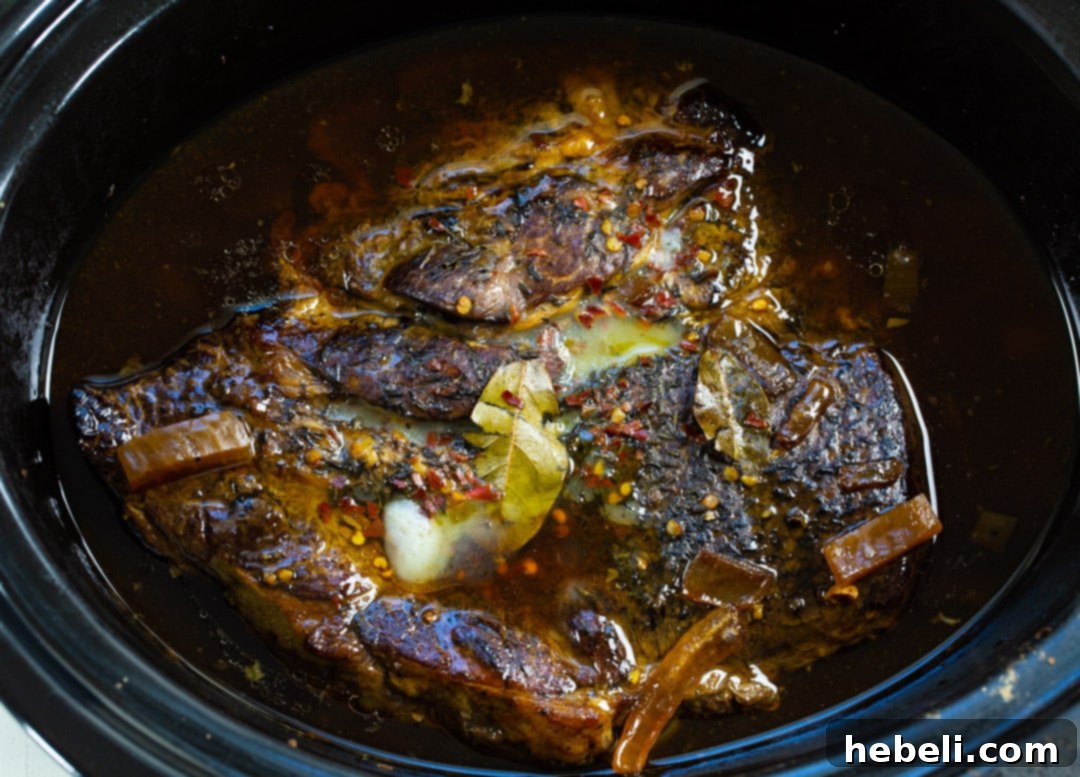 Cooked chuck roast in slow cooker before it is shredded.