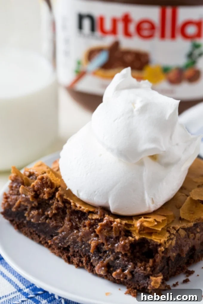Close-up of a perfectly baked Nutella Gooey Butter Cake, showcasing its rich chocolate crust and gooey hazelnut cream cheese topping.