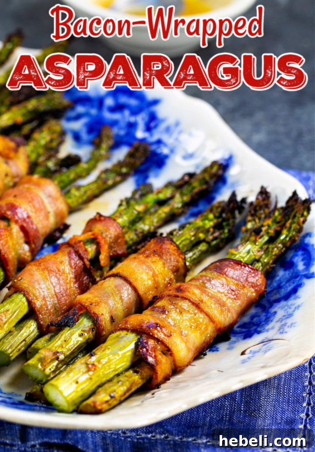 A row of perfectly cooked Bacon Wrapped Asparagus Bundles, showcasing their crispy bacon and vibrant green asparagus.