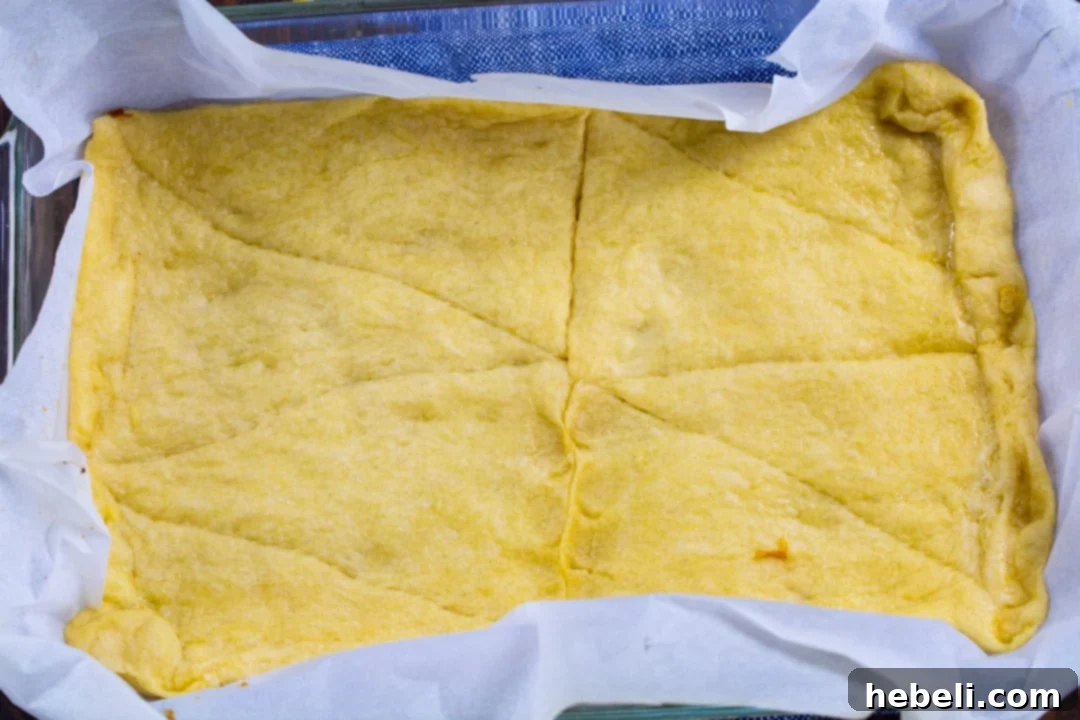 Zesty Lemon Cream Cheese Bars 3 Bottom crescent dough crust, perfectly golden brown after being partially baked, ready for filling.