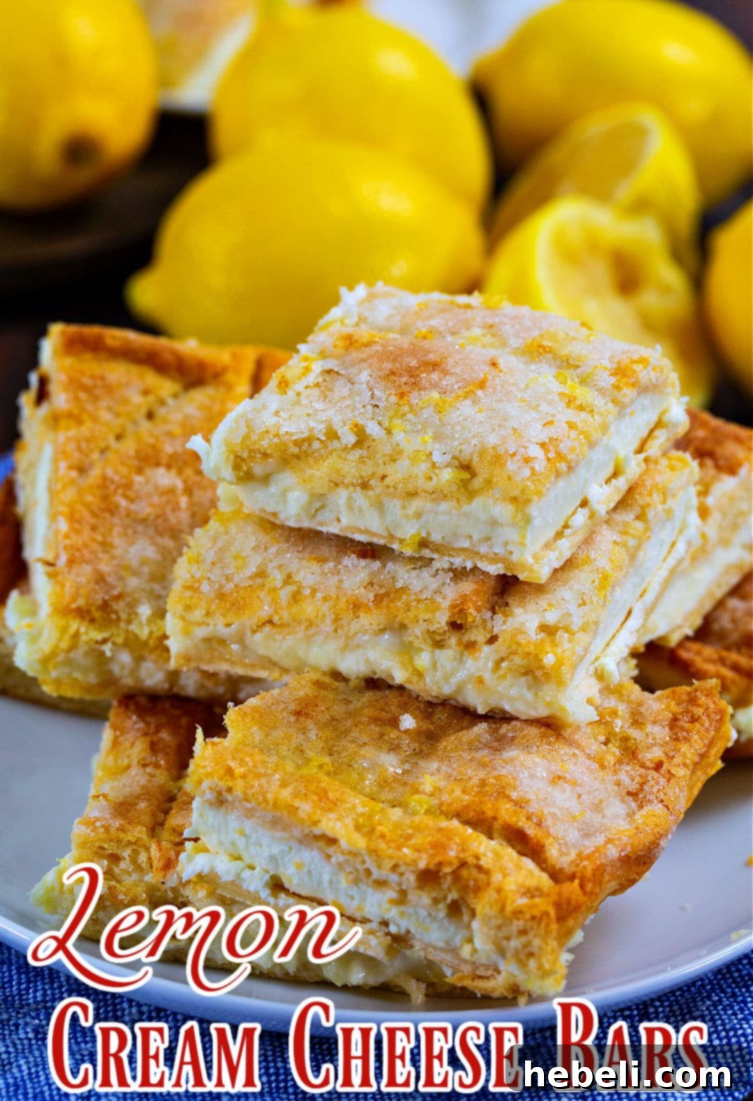Zesty Lemon Cream Cheese Bars 6 Beautifully stacked Lemon Cream Cheese Bars, garnished with a sprinkle of powdered sugar, ready to be enjoyed.