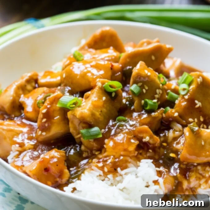 Delicious Instant Pot Honey Sesame Chicken served over fluffy white rice, garnished with vibrant green onions and toasted sesame seeds, ready to be enjoyed as a family meal.