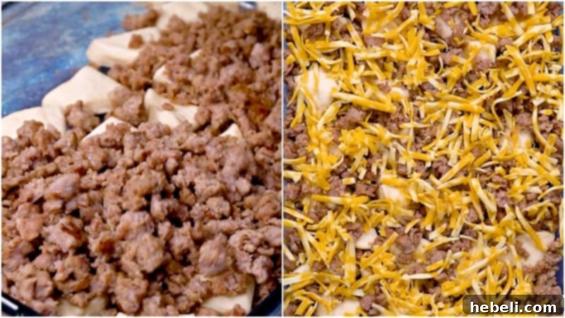 Layers of crumbled sausage and shredded cheese spread over the biscuits in a casserole dish.