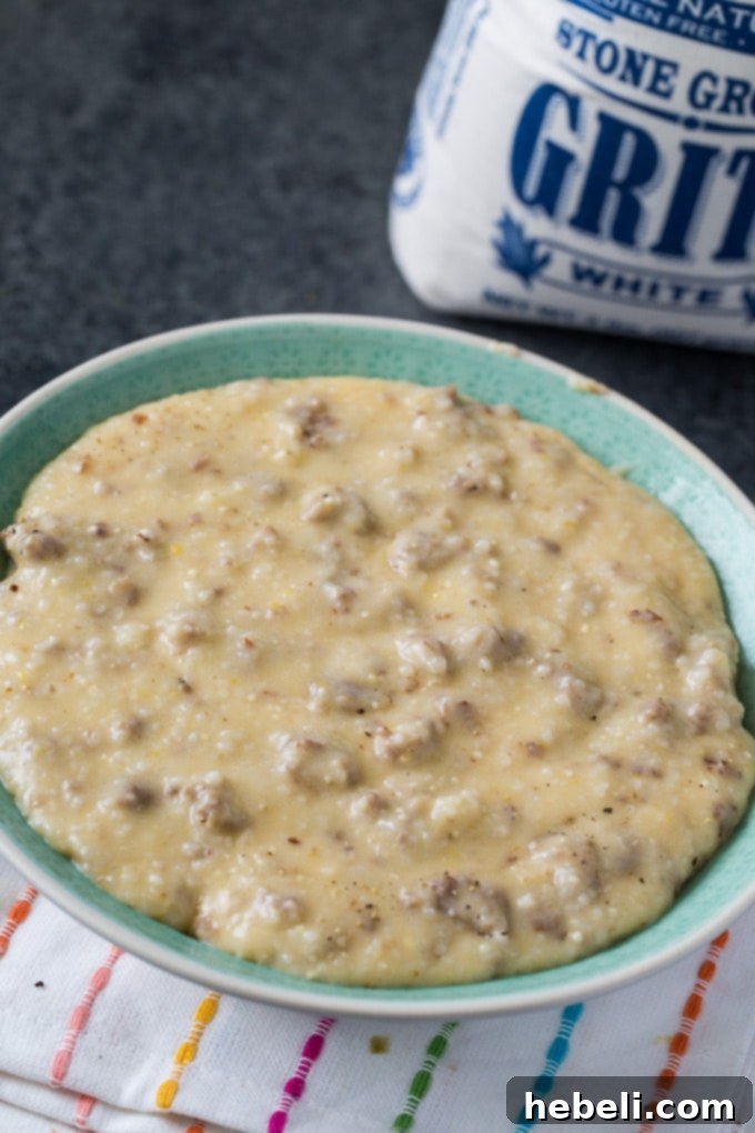 Plated Instant Pot Sausage Grits garnished with fresh herbs, ready to eat