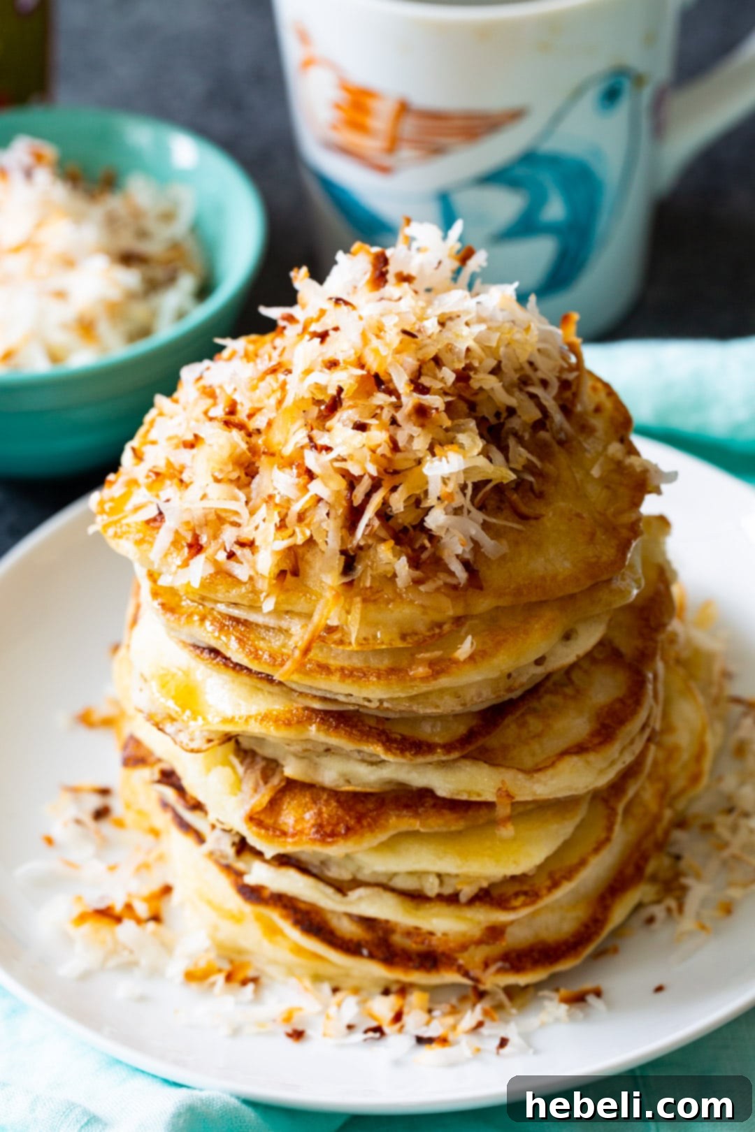 Tropical Coconut Pancakes 3 Stack of pancakes topped with toasted shredded coconut.