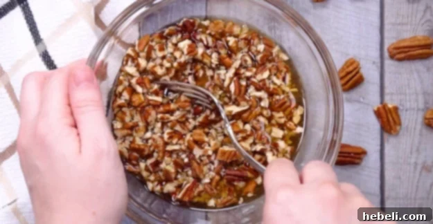 Pecans soaking in bourbon in a bowl.