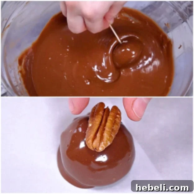 Dipping Bourbon Balls in melted chocolate and topping with a pecan.