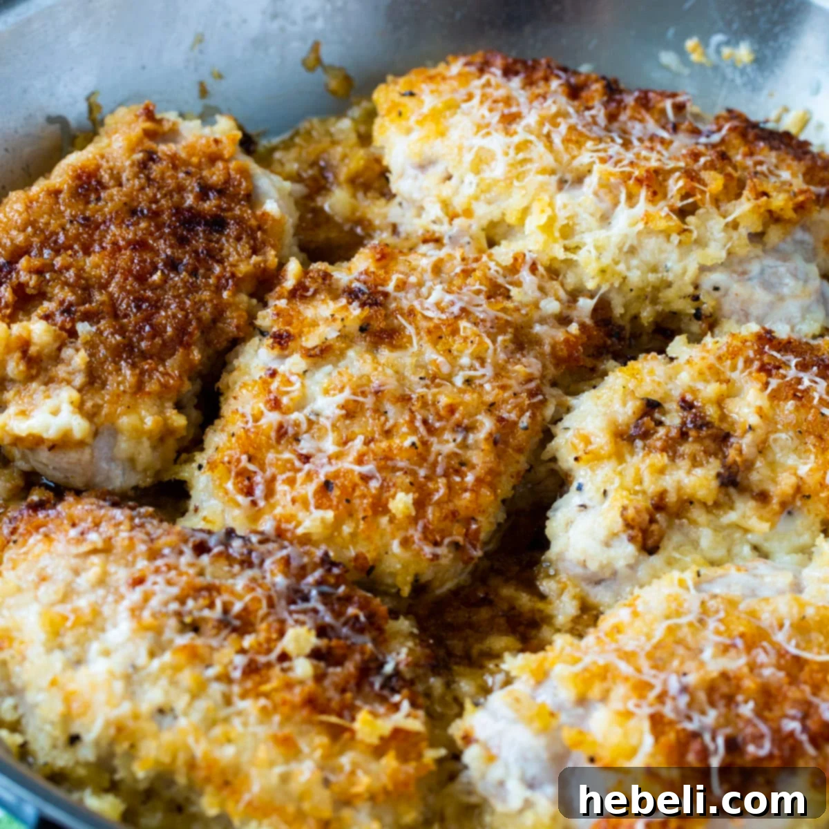 Buttermilk Parmesan Pork Chops in a skillet, showcasing their golden, crispy exterior.