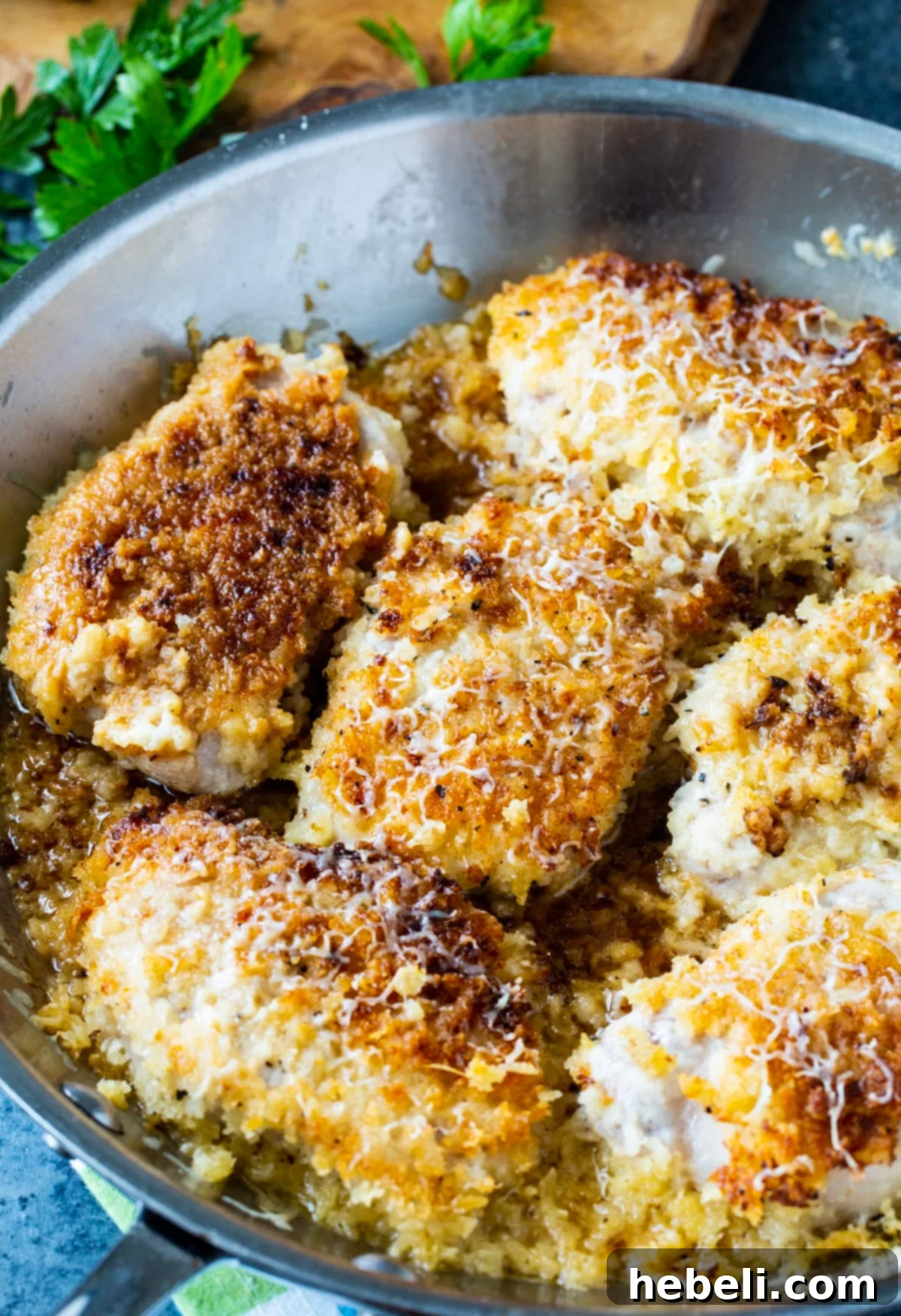 Pork Chops with a delicious crust cooking in a skillet.