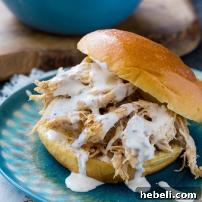 Slow Cooker Alabama White Pulled Chicken 2 Slow Cooker Pulled Chicken with Alabama White BBQ Sauce served on a bun with pickles