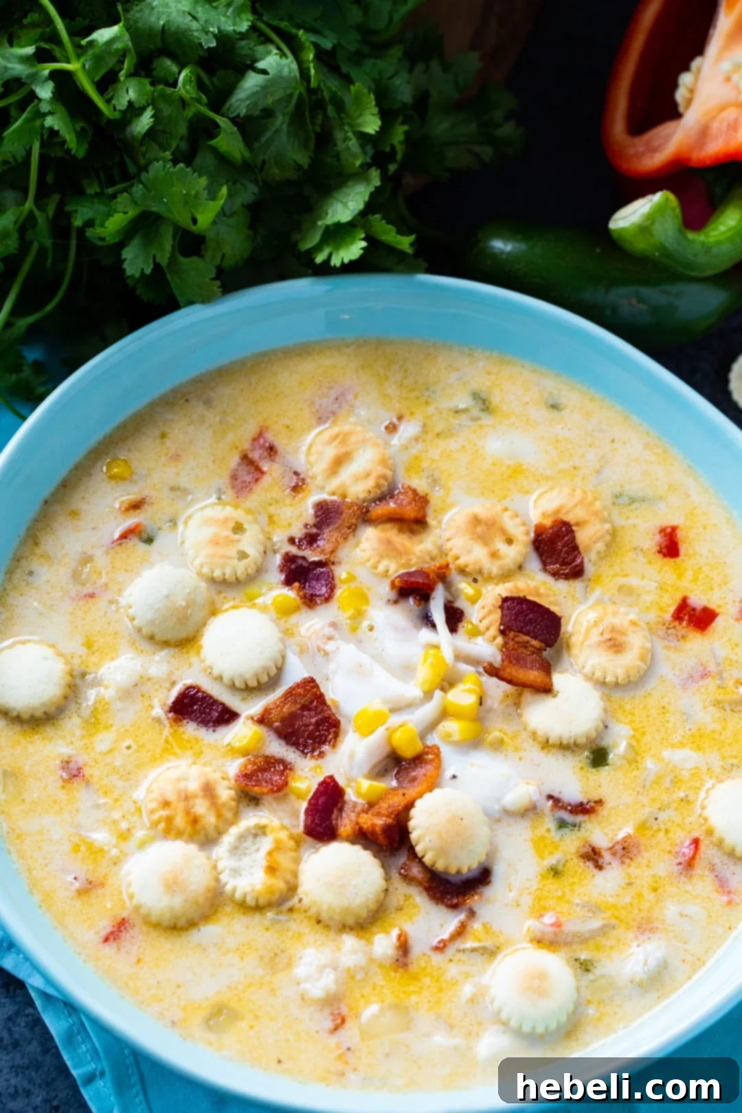 A close-up shot of creamy Crab Chowder in a rustic blue bowl, garnished with fresh parsley.