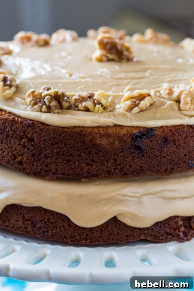 A delicious slice of Kentucky Blackberry Jam Cake topped with a generous swirl of caramel icing, ready to be enjoyed.