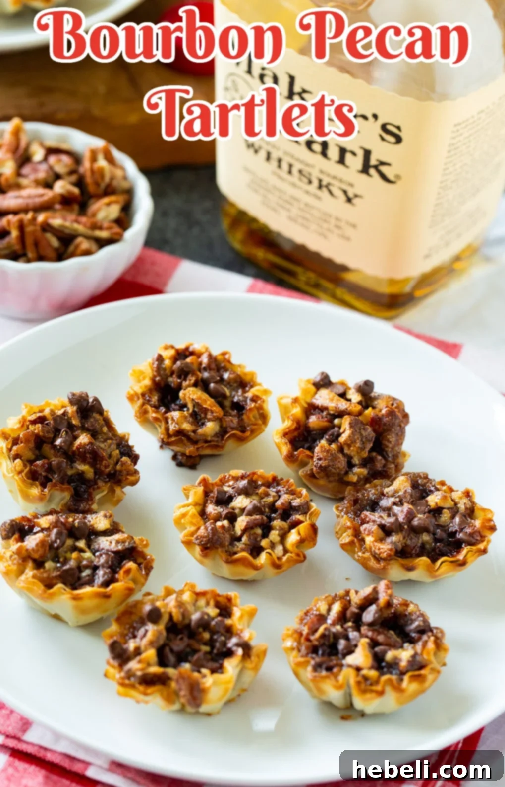 Whiskey-Kissed Pecan Mini Pies 4 A close-up of Bourbon Pecan Tartlets beside a bottle of bourbon, suggesting the key ingredient.