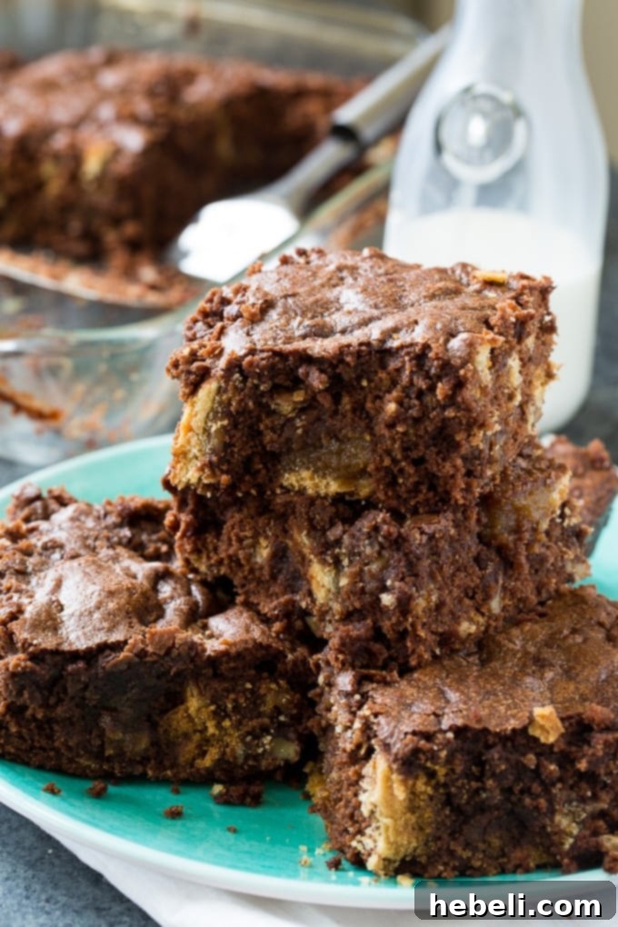 Close-up view of a baked Pecan Pie Brownie, showing visible chunks of pecan pie embedded within the rich chocolate brownie. Perfect for a holiday dessert table.